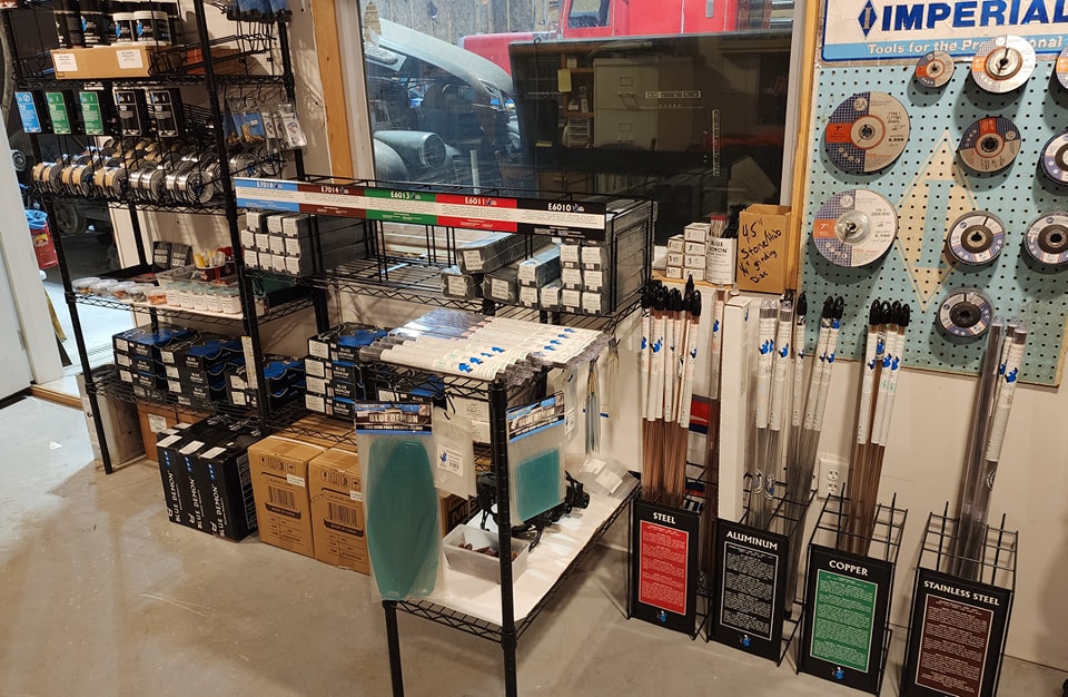 Welding supply storefront shelves with helmets, wire and gas cylinders